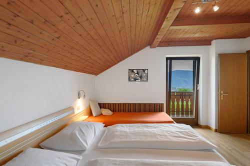 a bedroom with two beds and a large window at Harmony Apt 2 in Appiano sulla Strada del Vino