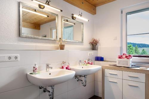 a bathroom with two sinks and a mirror at Sonnerhof Hofsgrund in Oberried