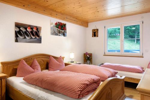 a bedroom with two beds with red and white pillows at Sonnerhof Hofsgrund in Oberried