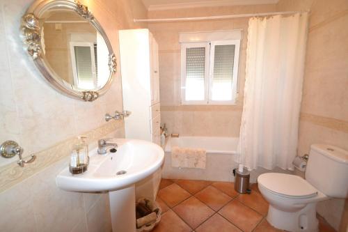 a bathroom with a sink and a toilet and a mirror at Casa Papa in San Fulgencio