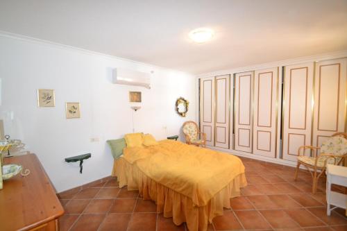 a bedroom with a bed with a yellow blanket on it at Casa Papa in San Fulgencio