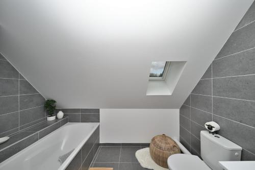 a bathroom with a toilet and a bath tub at Superbe appartement - Face au lac in Génos