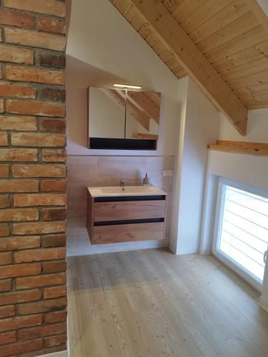 a bathroom with a sink and a brick wall at Kleine Auszeit 1 in Forst