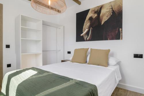a bedroom with a bed with an elephant picture on the wall at Apartamentos Habana 5 in Barbate