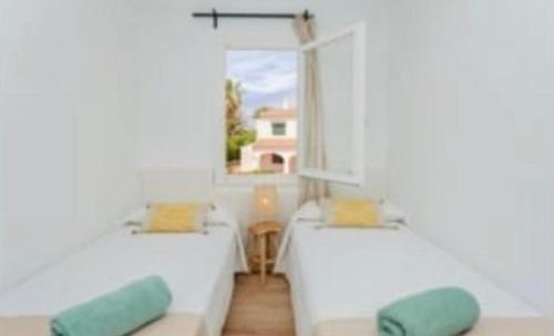 a living room with a couch and a window at Miret in Cala en Bosc