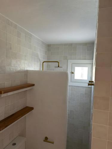 a bathroom with a toilet and a window at Miret in Cala en Bosc