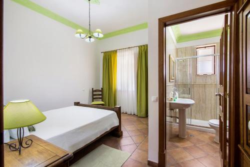 a bedroom with a bed and a sink and a bathroom at Casas do Monte in Giões