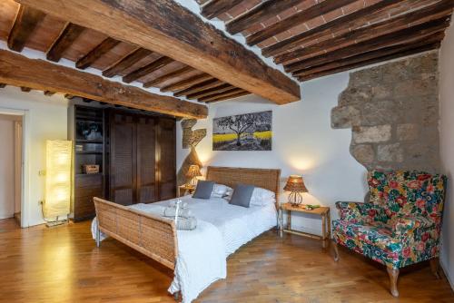 a bedroom with a bed and a chair at Appartamento del Campo - Siena in Siena
