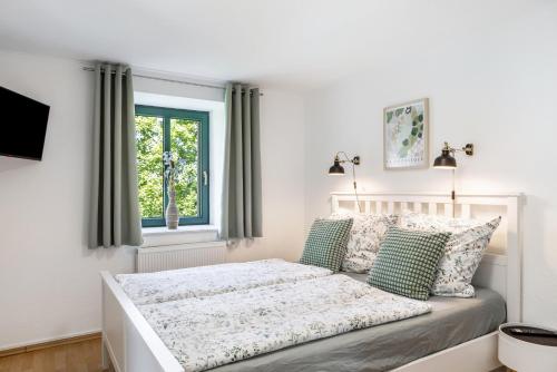 biała sypialnia z łóżkiem i oknem w obiekcie Ferienwohnung Villa Funcke w mieście Eisenach