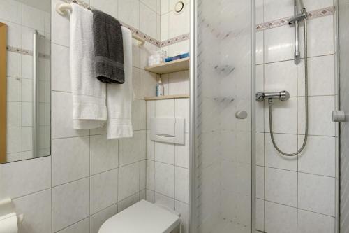 a white bathroom with a shower and a toilet at Ferienwohnung Manuela in Sankt Englmar