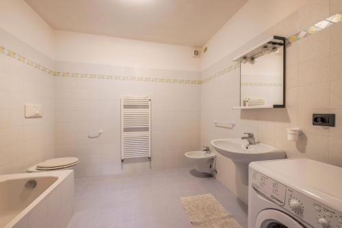 a white bathroom with a sink and a toilet at Villa Mazzel - Cima 12 in Vigo di Fassa