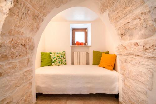 a bedroom with a bed in a stone wall at Trulli Orma in Martina Franca