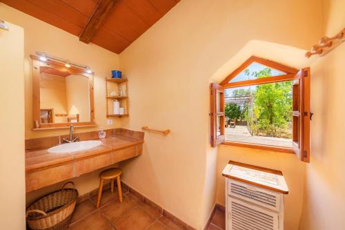 a bathroom with a sink and a window at Can Colau in Santa Margalida