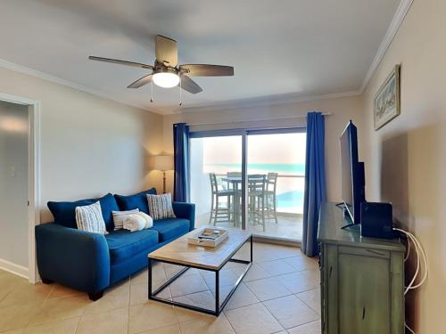 a living room with a blue couch and a table at Regency Towers #802 East in Pensacola Beach