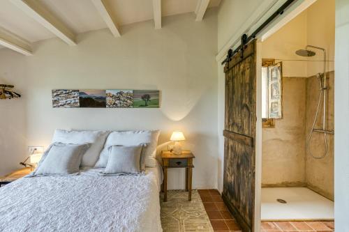 a bedroom with a bed and a shower at El Pedró Panoramic in Ventalló