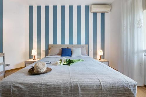 a bed with a hat and flowers on it at Appartamento Marilu Lake View in Brenzone sul Garda