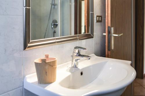 ein Badezimmer mit einem weißen Waschbecken und einem Spiegel in der Unterkunft Casa March 1 in Moena