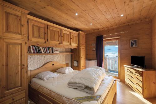 a bedroom with a bed with a wooden wall at Maison de village Puyvalador in Puyvalador
