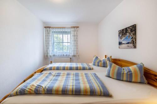 a bedroom with two beds and a window at Fewo Brünnstein - Nr 61 Pool, Sauna in Oberaudorf