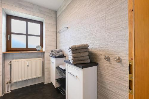 a bathroom with a towel rack and a window at Ferienwohnung Geyersberg 704 in Hauzenberg