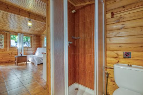 a bathroom with a toilet in a room with wooden walls at Entre Viejos Olivos in Benicolet