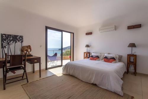 a bedroom with a bed and a desk and a window at Les Hauts de Figha in Conca