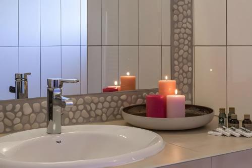 a bathroom sink with two candles and a mirror at Les Hauts de Figha in Conca