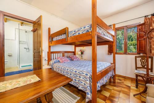 a bedroom with two bunk beds and a desk at Es Porcho in Deia