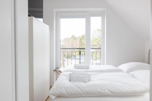 two beds in a white room with a window at Strand in Böhl