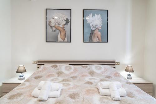 a bedroom with a large bed with three pictures on the wall at La Corte Rurale con jacuzzi in Lucca