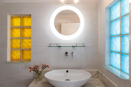 a bathroom with a white sink and a mirror at Afroditi Ftelia Gerani A in Mykonos