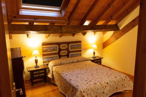 a bedroom with a bed and two tables with lamps at Kabila Enea 1 in Uztárroz