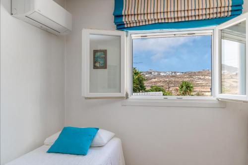 a bedroom with a window with a view of the city at Afroditi Ftelia Gerani A in Mykonos