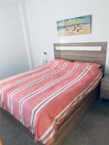 a bedroom with a bed with a red and white blanket at Fantastic apartment in Torrevieja