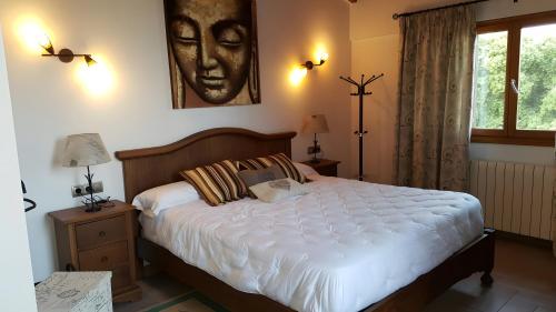 a bedroom with a large bed with a face on the wall at Casa las Columnas in Capdepera