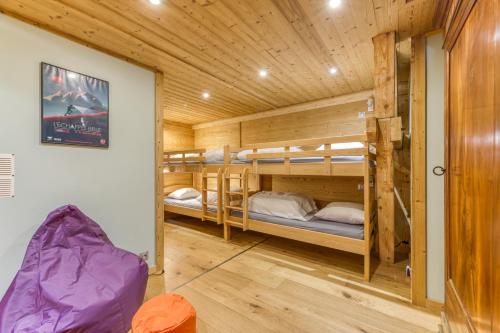 a room with bunk beds in a log cabin at Le Flocon Grand Chalet 4 étoiles in Villard-Reculas