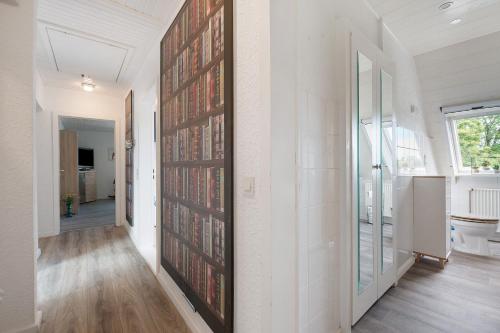 a hallway with a wall of books at Harmonie Wohnung in Oyten