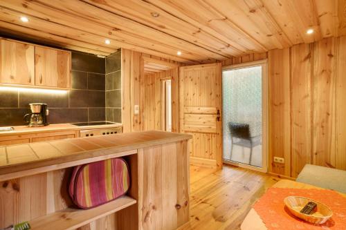 a kitchen with wooden cabinets and a counter in a room at Bungalow 19 - Finnhütte in Niesky