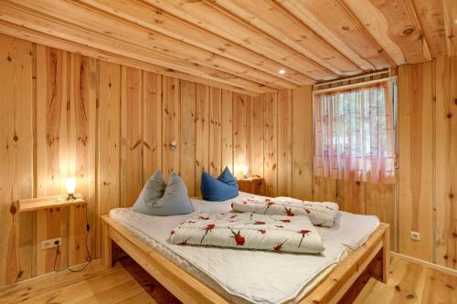 a bedroom with a bed in a wooden room at Bungalow 19 - Finnhütte in Niesky