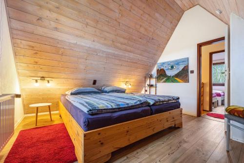 a large bedroom with a wooden wall at Ferienhaus Elbidylle in Bachenbrock