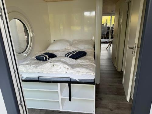 a bed in a small room with a mirror at Hausboot Kitilou in Flessenow