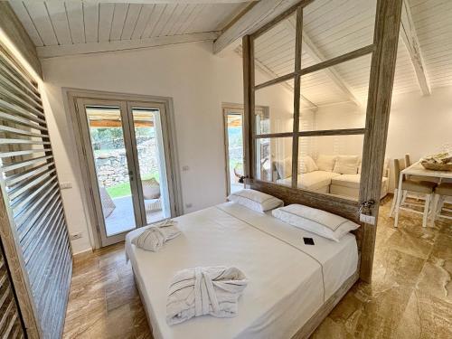 a bedroom with a large bed with a large window at Petra d'arana in Palau