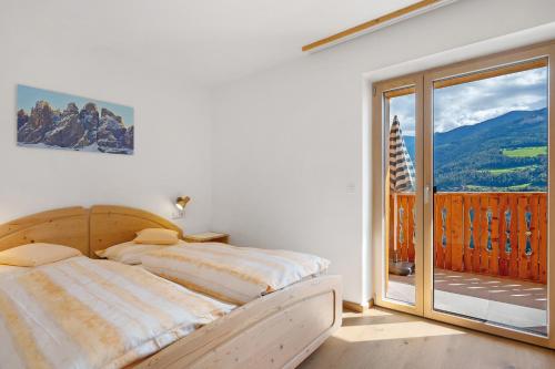 a bedroom with a bed and a large window at Oberhemberger Hof Feldthurns in Feldthurns