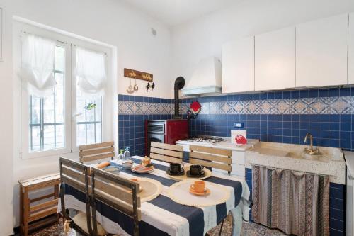 a kitchen with a table and chairs in a kitchen at Oasi in Alassio