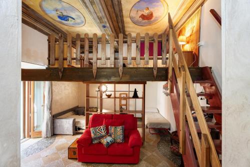 a living room with a loft bed and a red couch at Antro Di Circe - Orta Centro in Orta San Giulio
