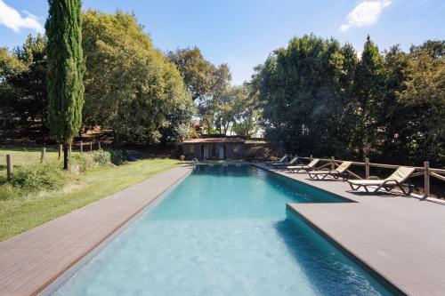 a swimming pool with chairs and a wooden deck at Casa de Andrães Pomar in Marco de Canaveses