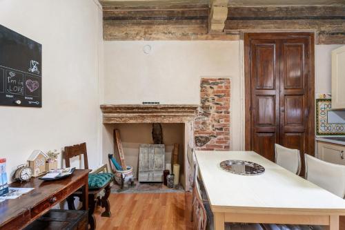 a kitchen with a table and a fireplace at Antro Di Circe - Orta Centro in Orta San Giulio