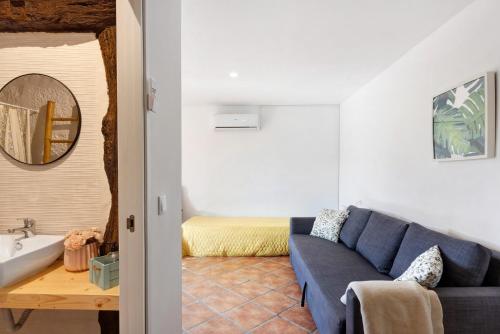 a living room with a blue couch and a bathroom at Casa de Andrães Pomar in Marco de Canaveses
