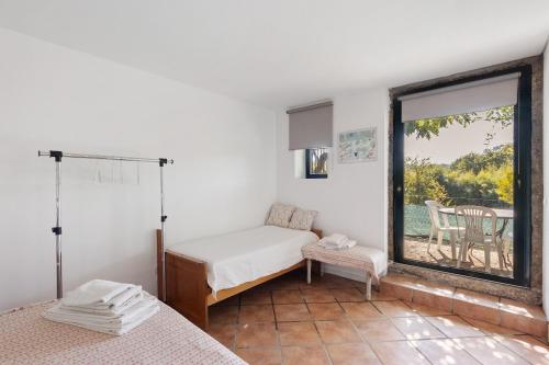 a bedroom with two beds and a large window at Casa de Andrães Pomar in Marco de Canaveses