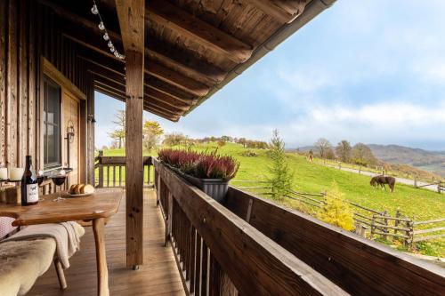 a porch with a table and a view of a field at Chalet Bergliebe in Brilon